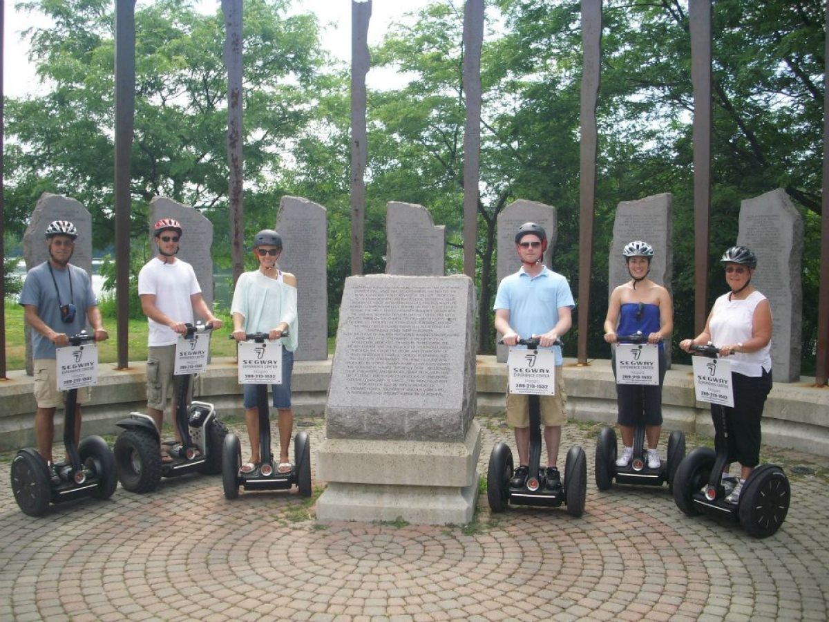 People next to a memorial on a segway